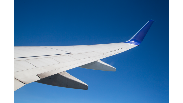 Close-Up Of Airplane Wing Against Clear Blue Sky