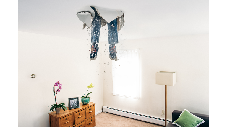 Man breaks ceiling drywall while doing DIY