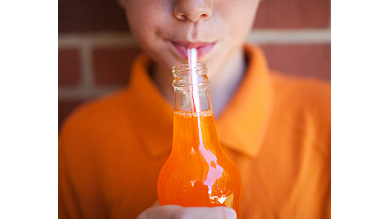 Boy drinking orange soda