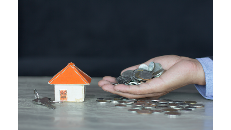 House models and coin in human hands, Mortgage concept by money house from the coins.
