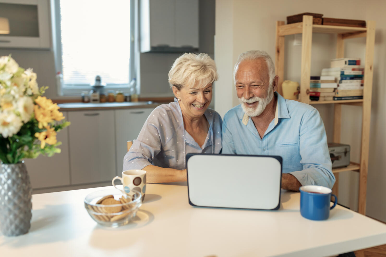 Mature couple browsing the internet and buying. Online shopping.