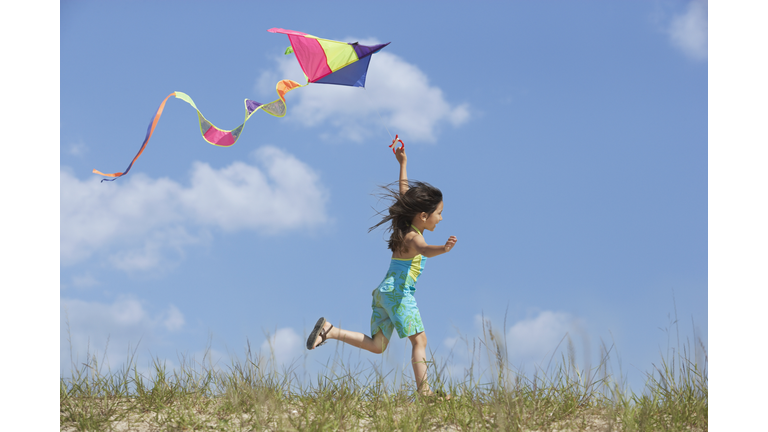 Hispanic girl flying kite