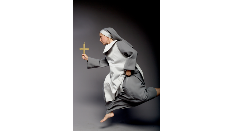 Nun Holding Cross and Running, On Gray Background
