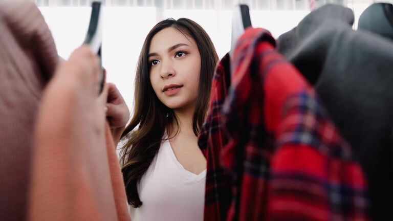 Young Woman Choosing Clothes From Closet