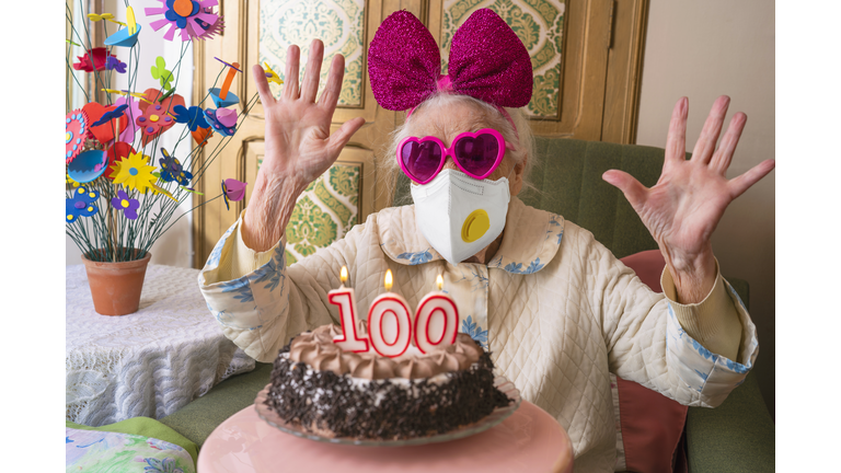 Coronavirus COVID-19 pandemic confinement with mask in 100 years old birthday cake old woman humor