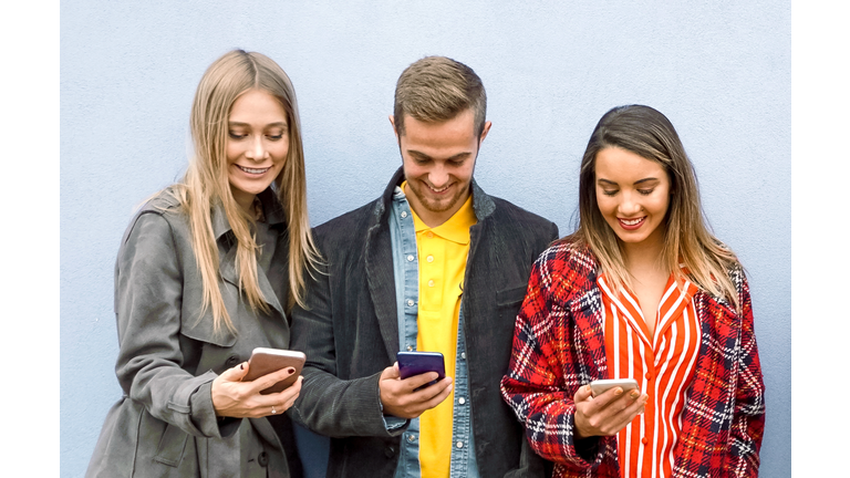 Friends using their smartphones and enjoying the company of each other- Young people shareing online stuff like photo and viedo on tik tok- Technology concept