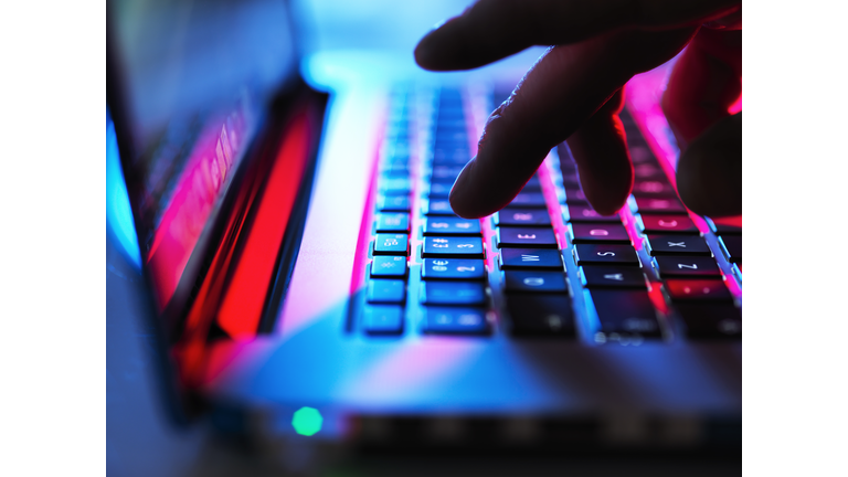 Man typing at his laptop computer at night