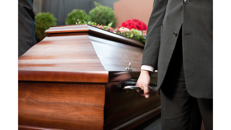 Funeral with casket carried by coffin bearer