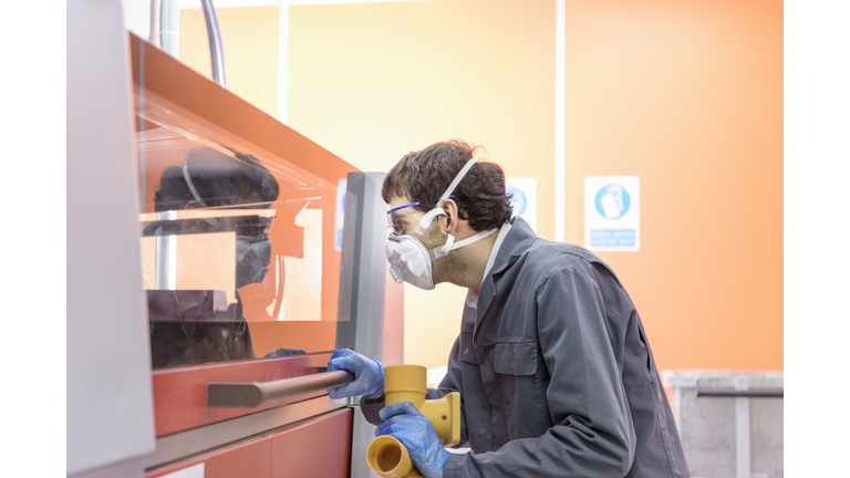 Worker 3D printing components in precision casting factory