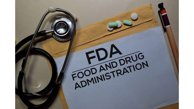 FDA - Food and Drug Administration text on document above brown envelope and stethoscope. Healthcare or medical concept