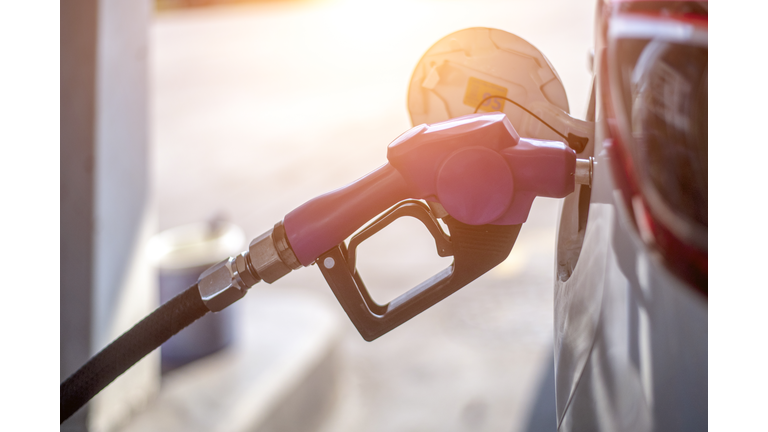 Fuel oil gasoline dispenser at petrol filling station.Holding fuel nozzle to refuel gasoline for car.