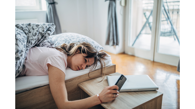 Sleepy woman looking at phone