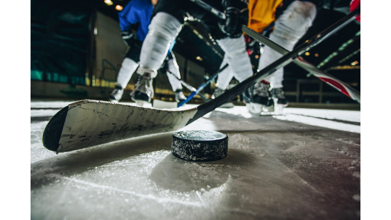 Close up of ice hockey puck and stick during a match.
