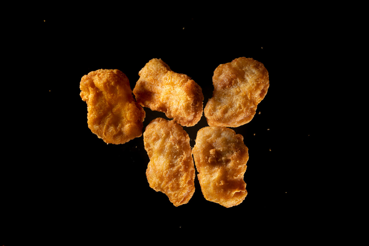 fried chicken Nuggets flying in mid air view from above