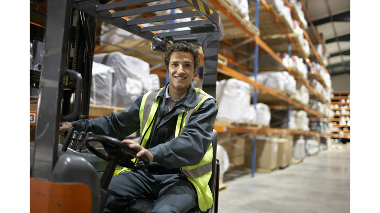 Worker on forklift, smiling to camera