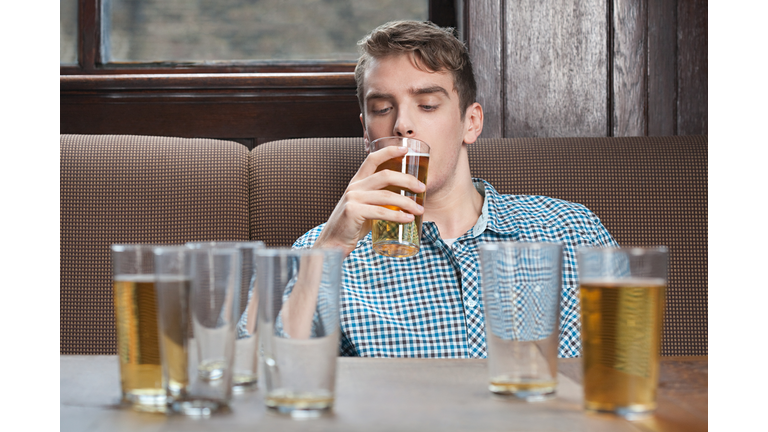 Young man drinking beer in bar