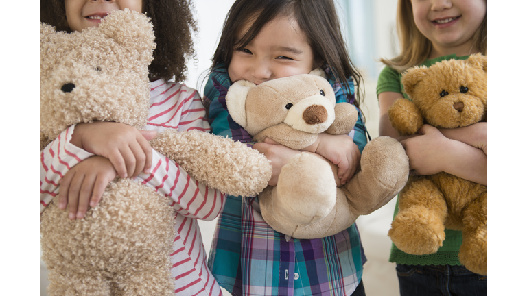 Girls hugging teddy bears