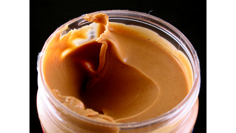 Close-up of an opened jar of creamy peanut butter