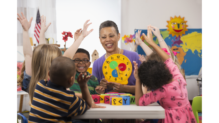 Kindergarten students and teacher reading clock