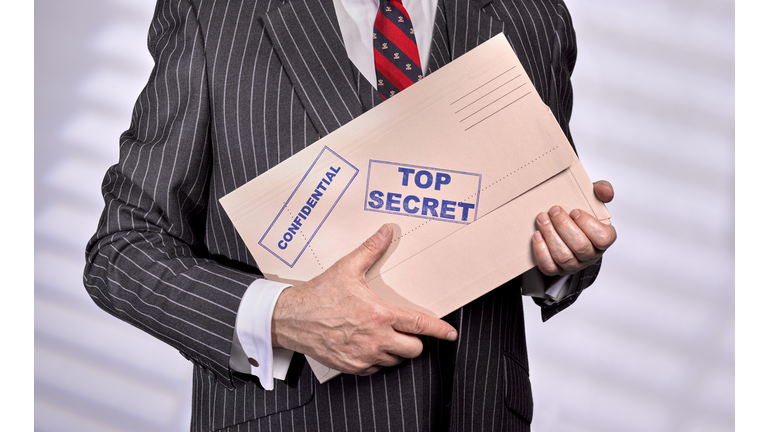 Businessman holding Confidential Top Secret Folder