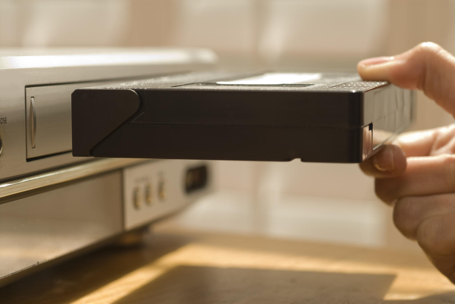 Hand putting VHS tape in a VCR