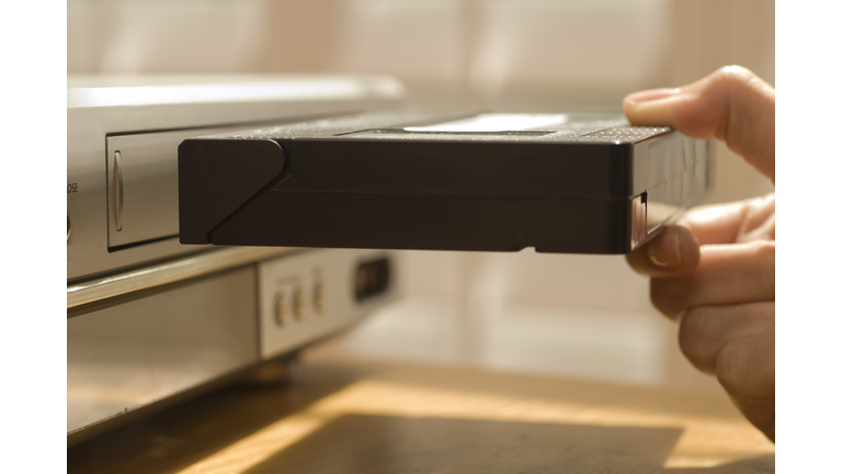 Hand putting VHS tape in a VCR