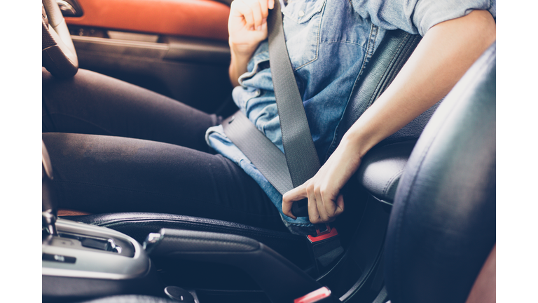 Asian woman fastening seat belt in the car, safety concept