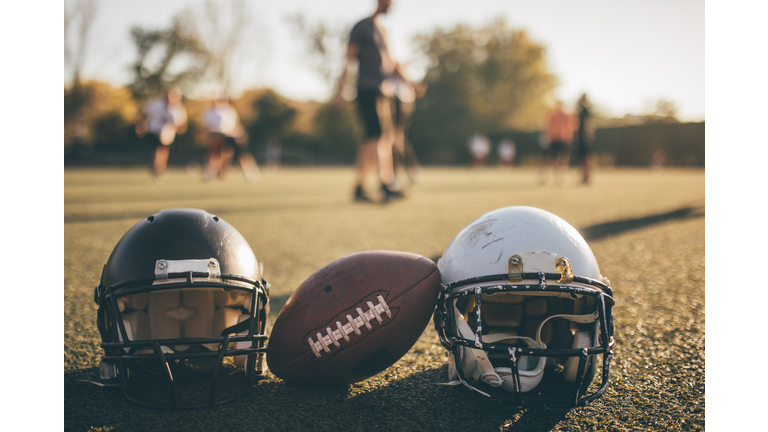 NFL helmets and ball on grass on training