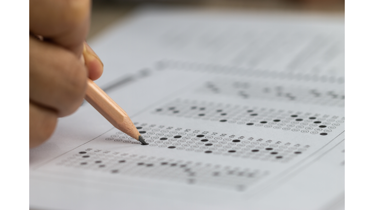 Education school test concept : Hands student holding pencil for testing exams writing answer sheet or exercise for taking fill in admission exam multiple carbon paper computer at university classroom