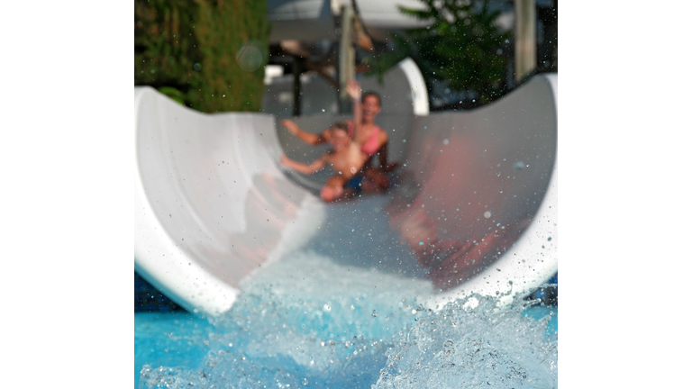 People On Water Slide In Park