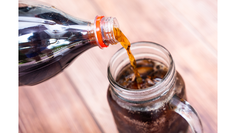 pouring coca cola sparkling water into a glass