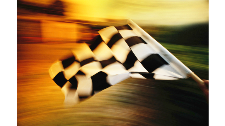 Checkered flag waving at an car race.