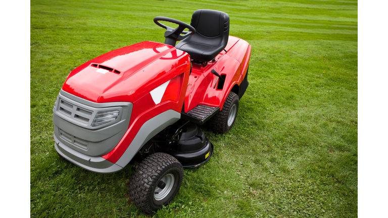 Red riding mower parked on the grass