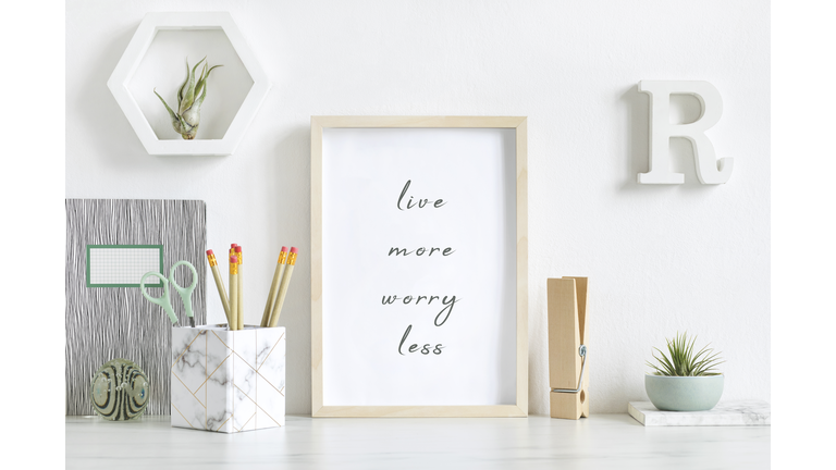 Modern and stylish home interior with white mock up poster frame, design office accessories, tapes, supplies, notes, memo sticks, air plants. Scandinavian home decor. Minimalistic concept. Template.