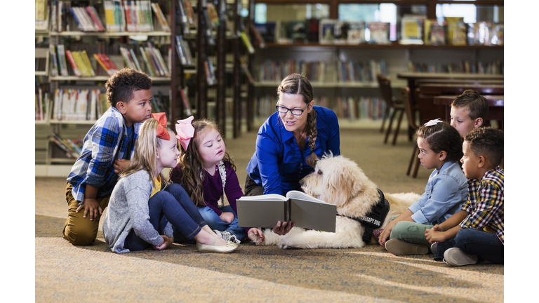 Children in library with reading assistance dog