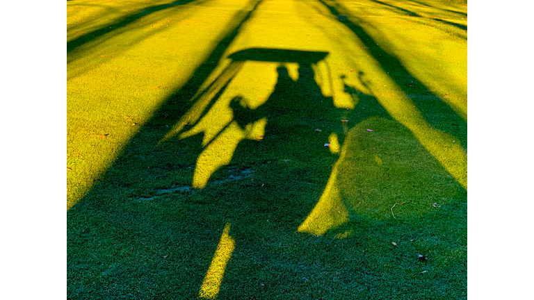 Shadow of a Man Travel with a Golf Cart on Golf Course