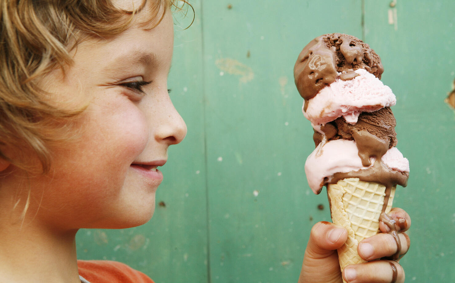 Close up of boy (6-7) holding ice cream cone, side view