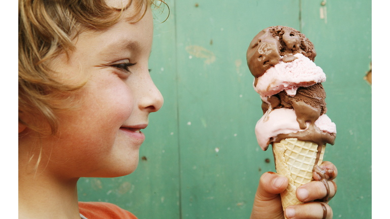 Close up of boy (6-7) holding ice cream cone, side view