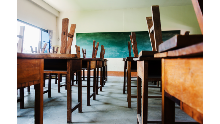 chair and table in class room with black board background, no student, school closed concept