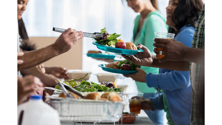 People receive food from volunteers in soup kitchen