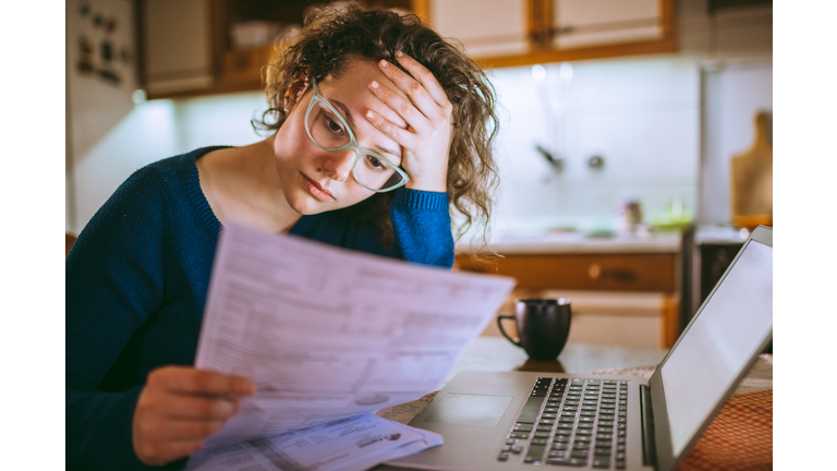 Woman going through bills, looking worried