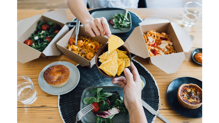 Couple Sharing Takeaway Meal At Dining Table