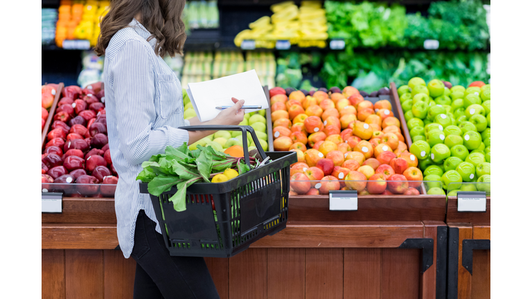 Unrecognizable woman shops for produce in supermarket