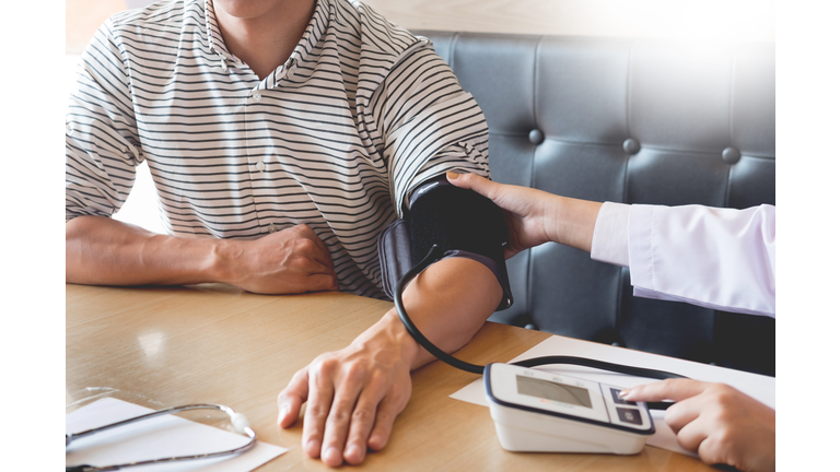 Cropped Image Of Doctor Checking Blood Pressure Of Patient