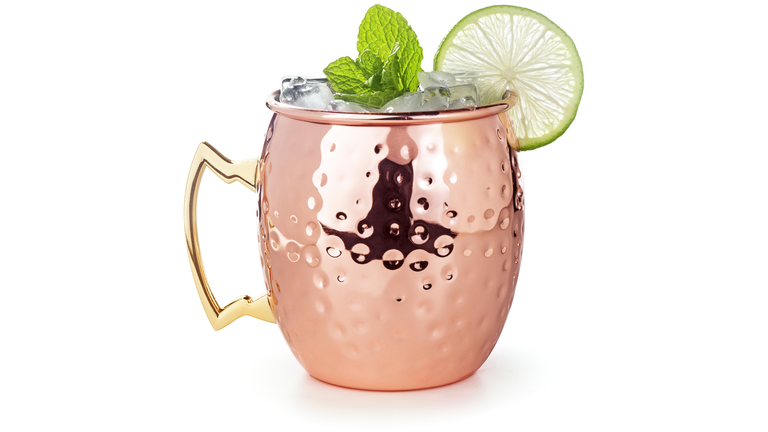 moscow mule cocktail in a copper mug isolated on white