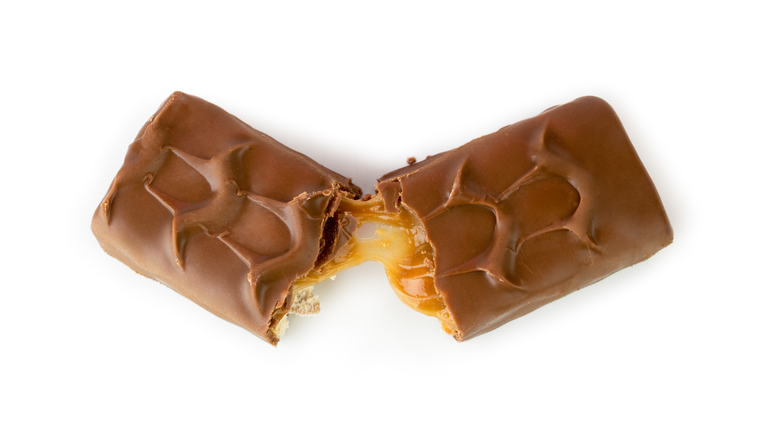 Chocolate Snickers broken in half on a white. The view from the top.