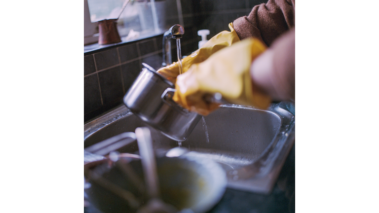 Young woman cleaning dishes