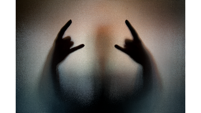 Silhouette of heavy metal horn sign hand gesture