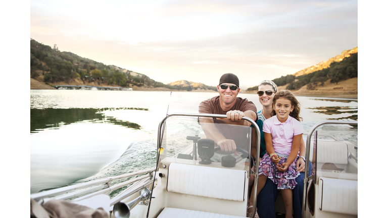 Girl and parents enjoying riding on boat