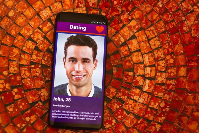 Smiling young man on mobile phone dating app